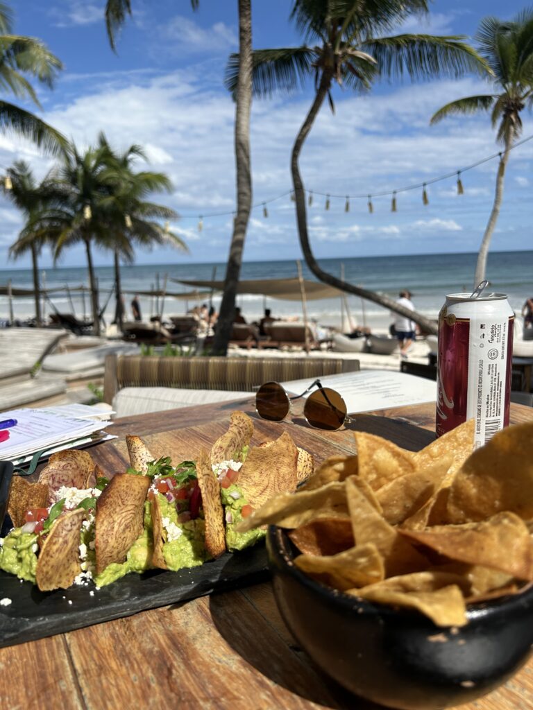 Guacamole and chips on table with the beach in the background