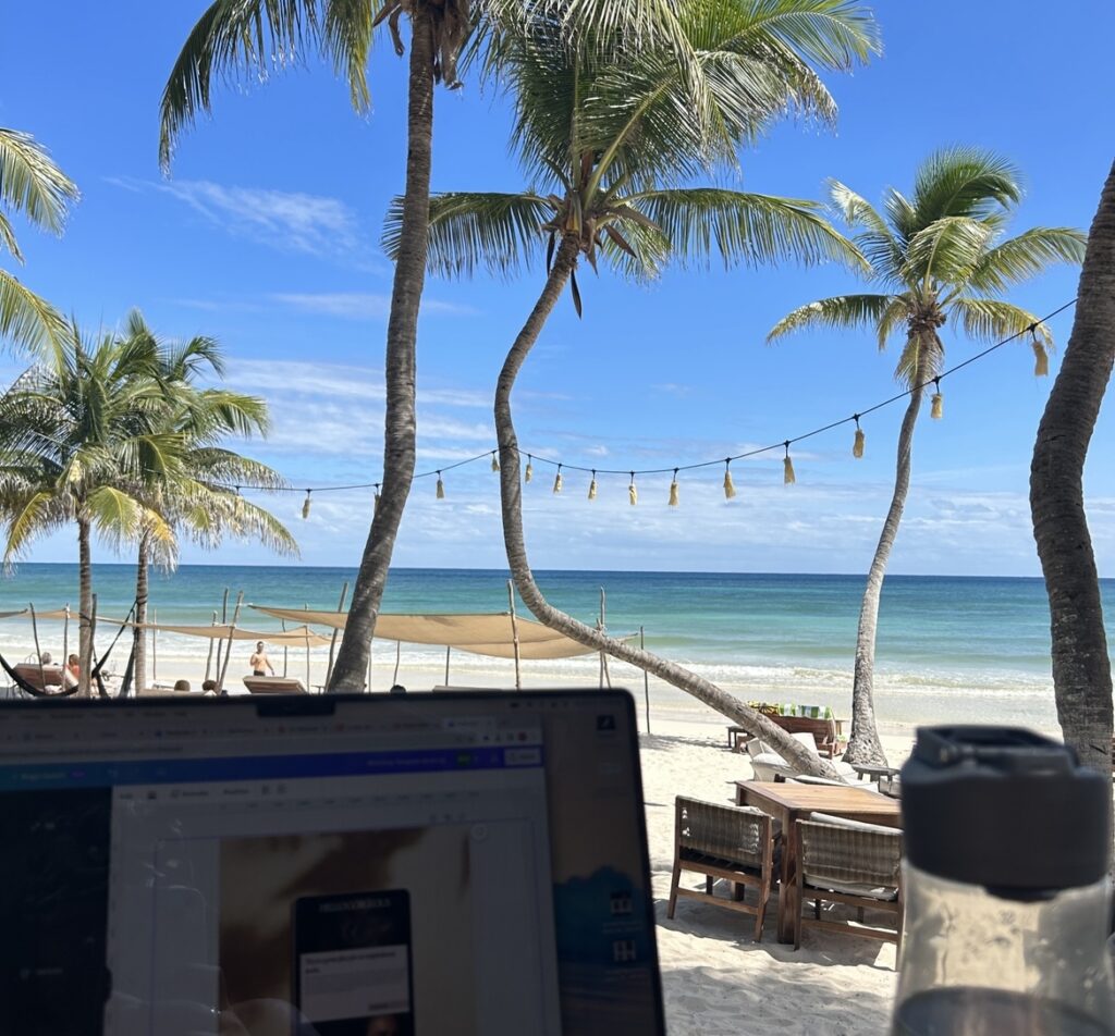 View of the beautiful beach from Aly's desk with her laptop